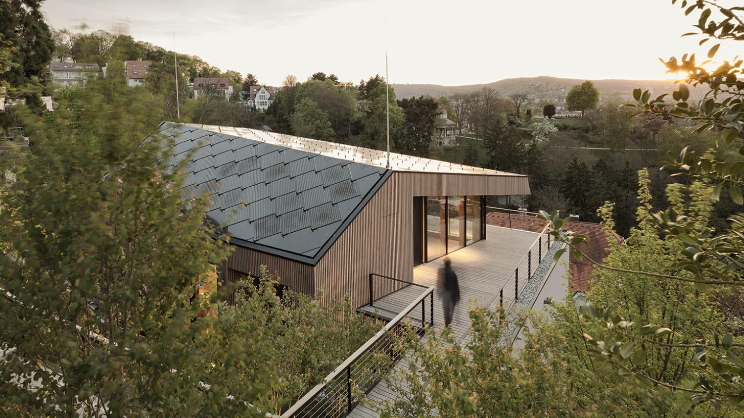 A modern wooden home with SunStyle dragonscale solar roof.
